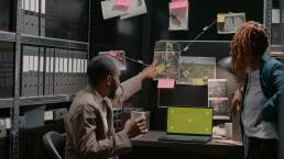 Two inspectors using greenscreen on laptop at desk